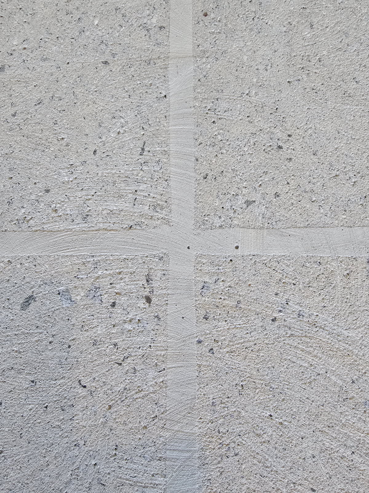 Close-up of a freshly ground concrete surface with control joints