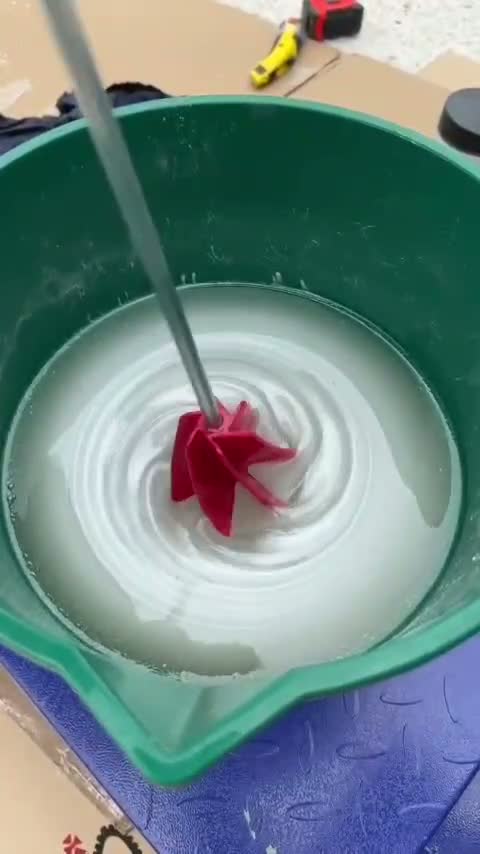 Epoxy being mixed with a paddle mixer in a bucket