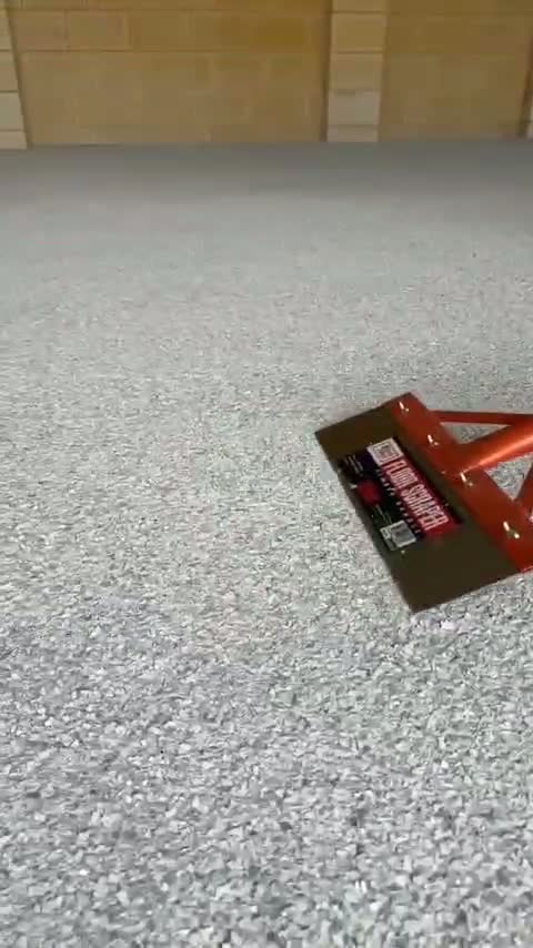 Decorative flakes being spread evenly across a freshly coated garage floor